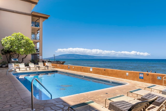 view of pool with a water and mountain view and a patio