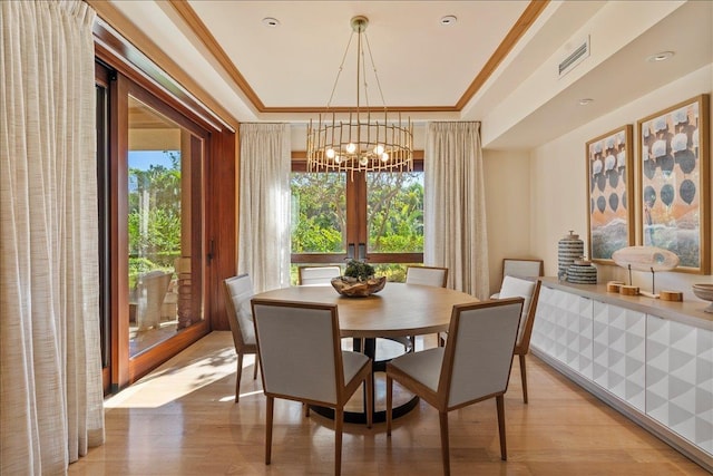 dining room featuring light hardwood / wood-style flooring, ornamental molding, and an inviting chandelier