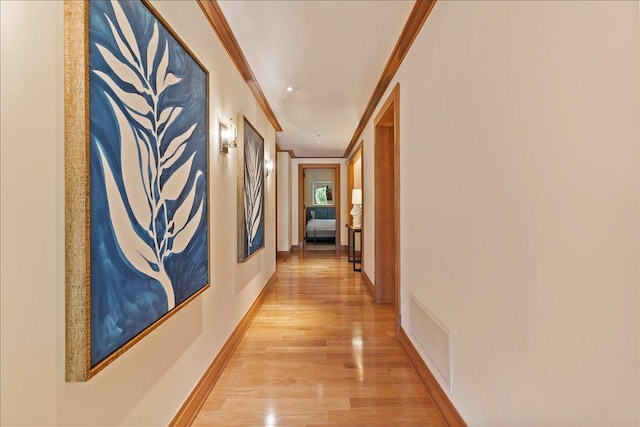 hall featuring light hardwood / wood-style flooring and crown molding