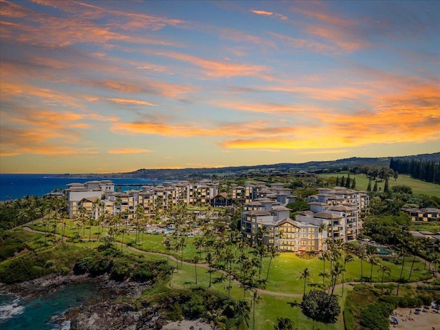 aerial view at dusk featuring a water view