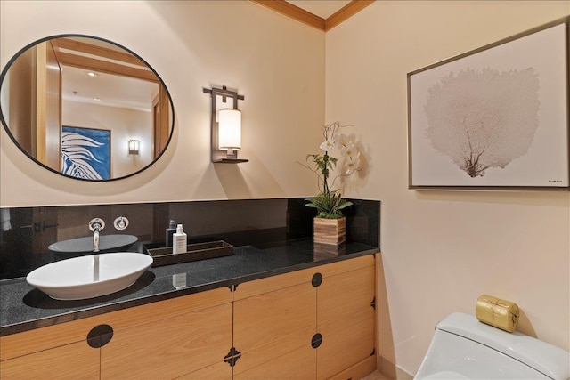 bathroom featuring vanity, toilet, and ornamental molding