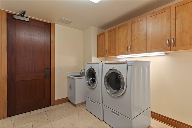 laundry room with cabinets, washing machine and dryer, and sink