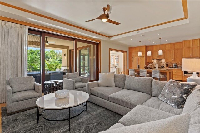 living room featuring a tray ceiling and ceiling fan