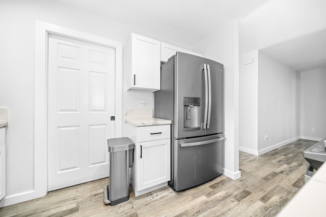 kitchen with stainless steel fridge with ice dispenser, light hardwood / wood-style floors, and white cabinets