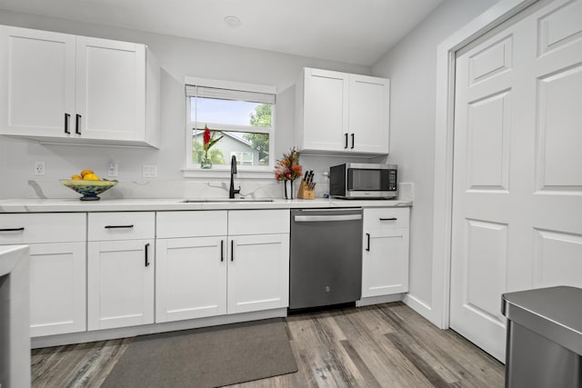 kitchen featuring white cabinetry, sink, light hardwood / wood-style flooring, and appliances with stainless steel finishes