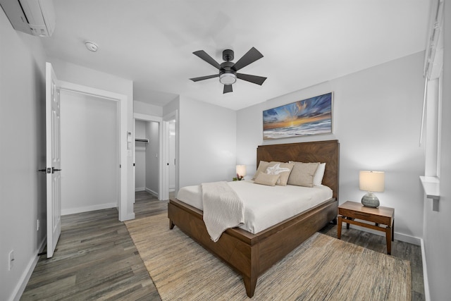 bedroom featuring a wall mounted air conditioner, hardwood / wood-style floors, and ceiling fan