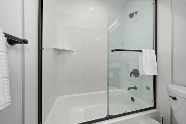 bathroom with enclosed tub / shower combo and toilet