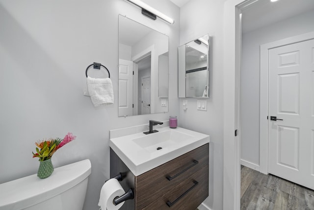 bathroom featuring vanity, hardwood / wood-style floors, and toilet