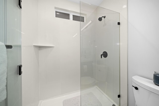 bathroom with toilet and an enclosed shower