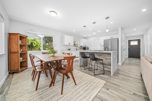 dining space featuring sink and light wood-type flooring