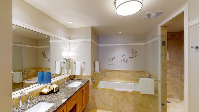 bathroom with vanity and shower with separate bathtub