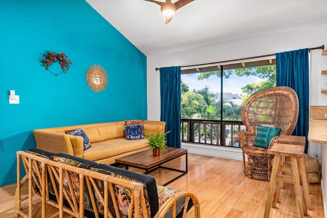 living room with ceiling fan, wood-type flooring, and lofted ceiling