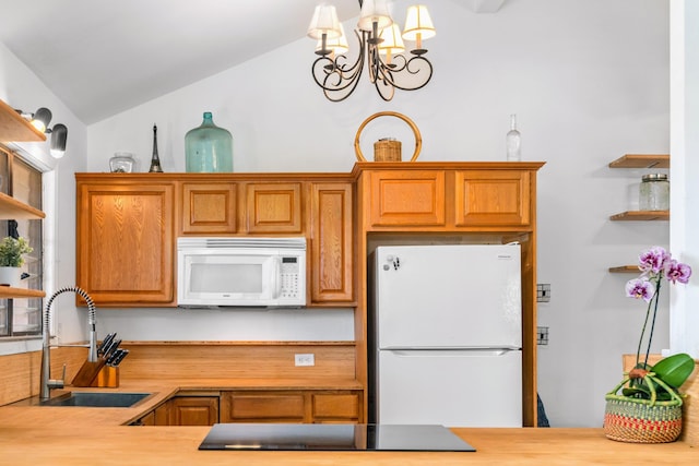 kitchen featuring wood counters, white appliances, sink, vaulted ceiling, and a chandelier