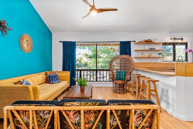 living room featuring ceiling fan, light wood-type flooring, and a wealth of natural light