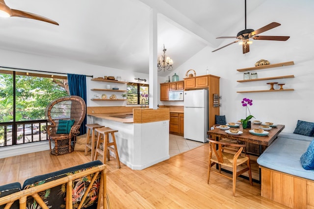 kitchen with kitchen peninsula, a breakfast bar, white appliances, light hardwood / wood-style flooring, and beamed ceiling