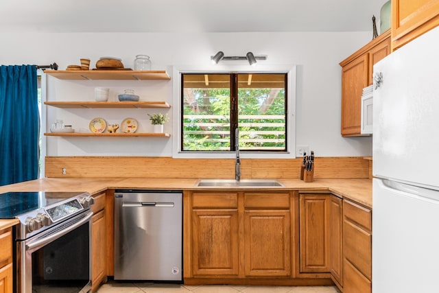 kitchen with sink, light tile patterned floors, and stainless steel appliances