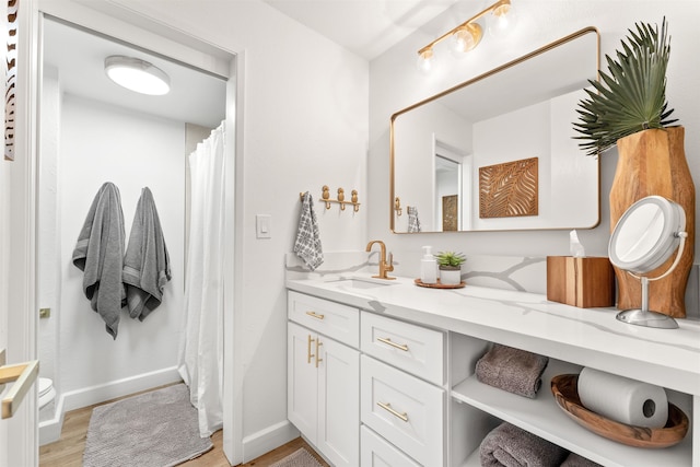 bathroom with hardwood / wood-style flooring and double sink vanity