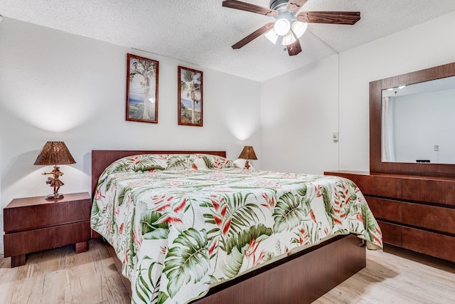 bedroom featuring a textured ceiling, ceiling fan, and light hardwood / wood-style flooring