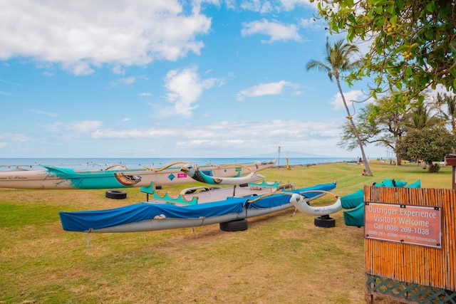 view of jungle gym featuring a water view and a lawn