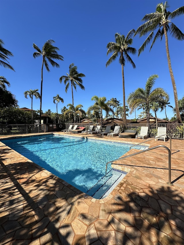 community pool with a patio and fence