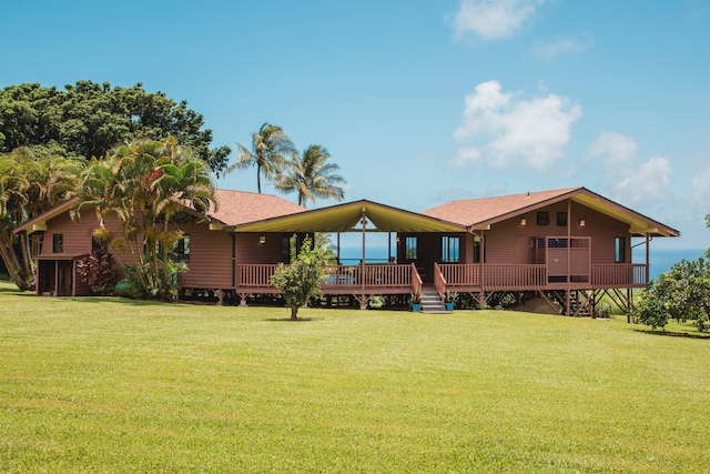 rear view of house featuring a lawn and a wooden deck