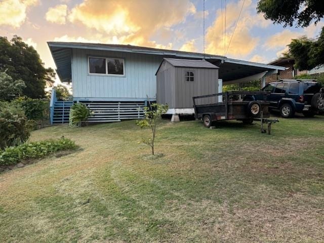 outdoor structure at dusk featuring a carport and a lawn