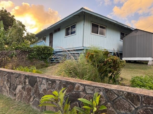 property exterior at dusk with a storage unit