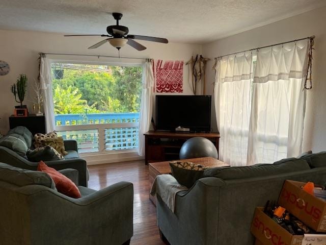 living room with hardwood / wood-style flooring, ceiling fan, and a textured ceiling