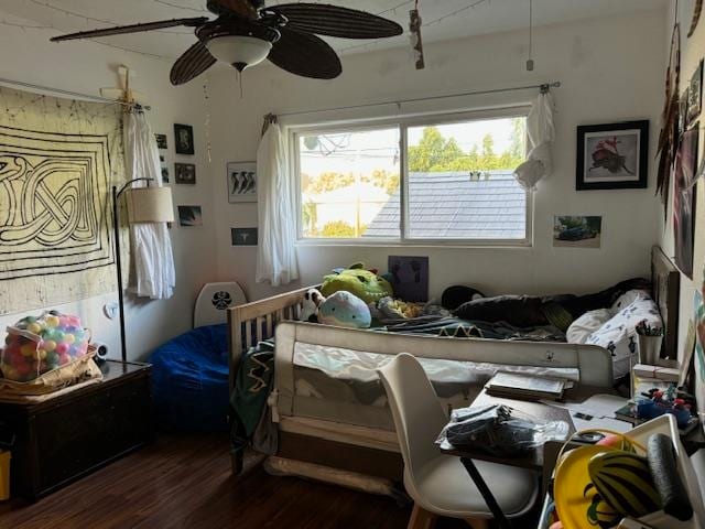 bedroom with dark hardwood / wood-style flooring and ceiling fan