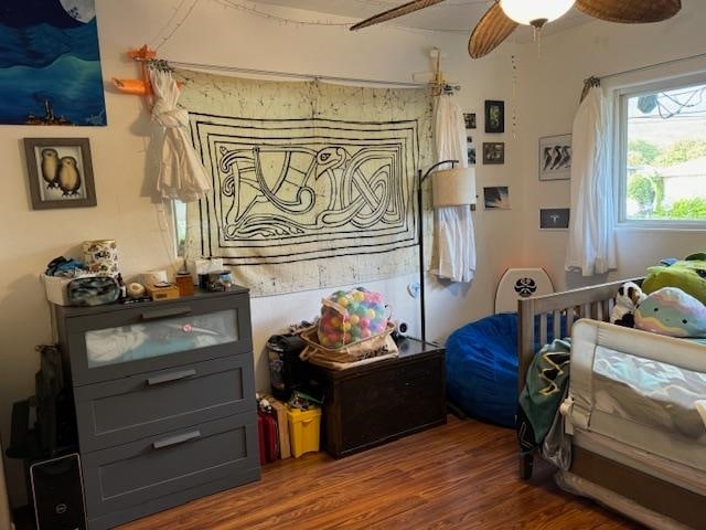 bedroom with dark hardwood / wood-style flooring and ceiling fan