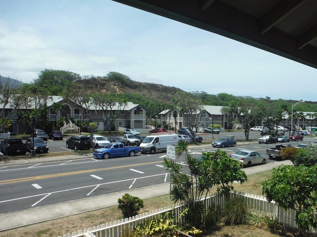 view of vehicle parking featuring a residential view and fence