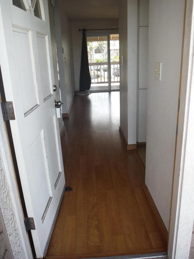 hall featuring wood finished floors and baseboards