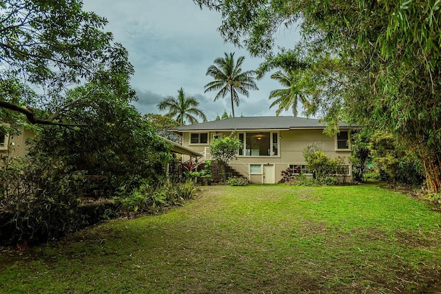 rear view of house featuring a lawn