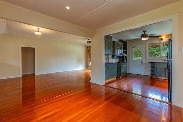 unfurnished living room featuring ceiling fan and hardwood / wood-style floors