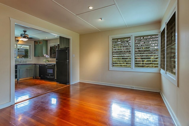 interior space featuring wood-type flooring, sink, ceiling fan, and a healthy amount of sunlight