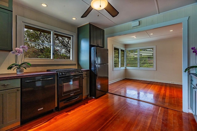 kitchen with plenty of natural light, black appliances, light hardwood / wood-style floors, and ceiling fan