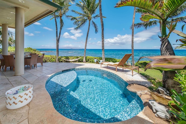 view of pool with a water view, a hot tub, and a patio area