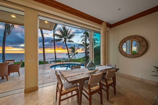 dining space with a water view, ornamental molding, and light tile patterned floors