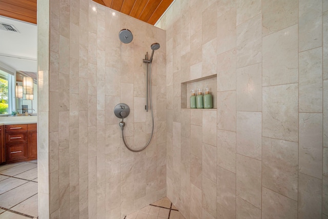 bathroom with wood ceiling, vanity, and a tile shower