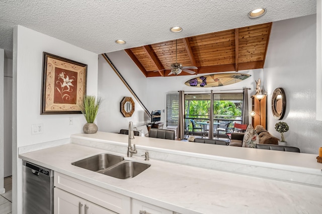 kitchen featuring lofted ceiling with beams, sink, white cabinets, ceiling fan, and stainless steel dishwasher