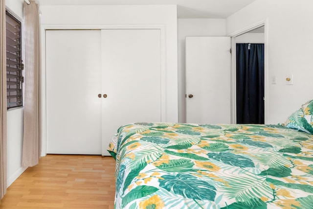 bedroom with light hardwood / wood-style flooring and a closet