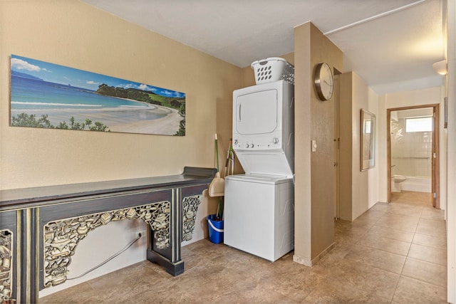 laundry room with stacked washer and dryer and light tile patterned floors