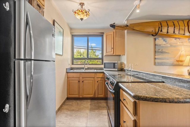 kitchen featuring stainless steel appliances, sink, and hanging light fixtures