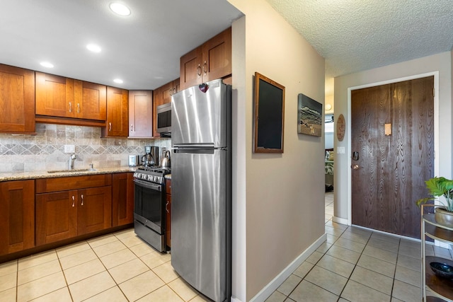 kitchen featuring light tile patterned flooring, stainless steel appliances, sink, and decorative backsplash