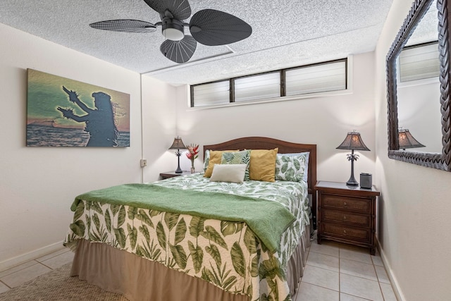 bedroom with ceiling fan, light tile patterned floors, and a textured ceiling