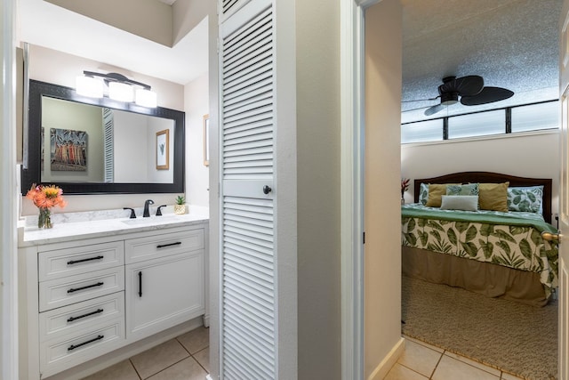 bathroom with ceiling fan, tile patterned floors, and vanity