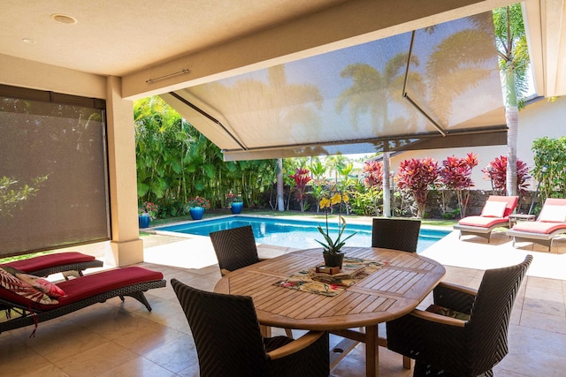 view of patio with outdoor dining space, a fenced backyard, and an outdoor pool