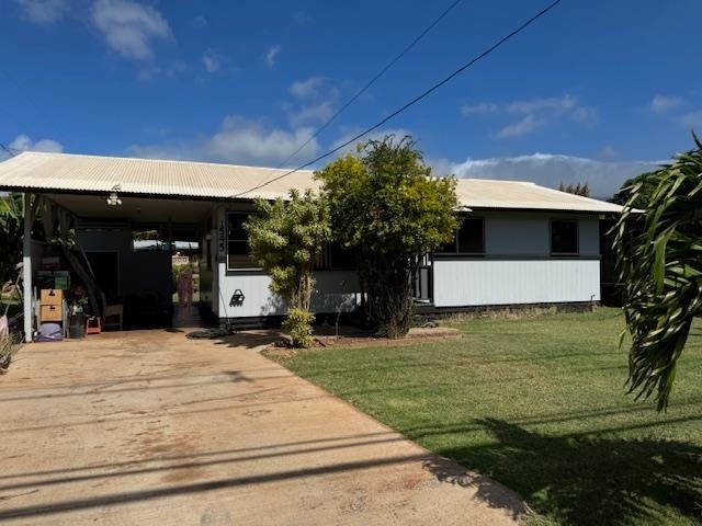 view of front facade featuring a carport and a front lawn