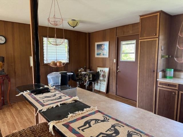 kitchen featuring wood walls, decorative light fixtures, and light hardwood / wood-style floors