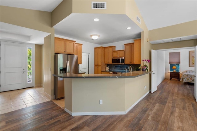 237 Kuli Puu St, Kihei, HI 96753 - kitchen with stainless steel appliances, wood finished floors, a peninsula, dark countertops, and baseboards
